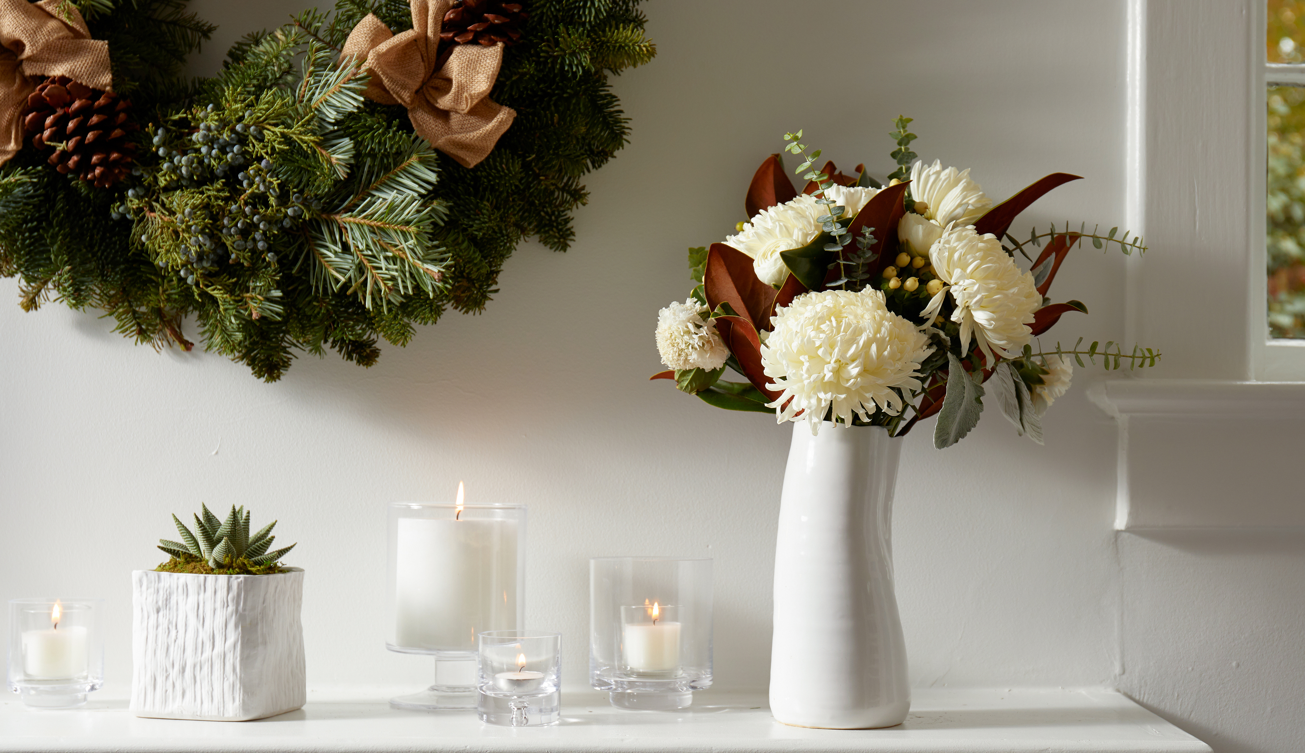 holiday mantle with seasonal wreath and bouquet with magnolia leaves